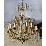 A CONTEMPORARY EIGHTEEN LIGHT GILT METAL ELECTROLIER OR CHANDELIER with scrolling arms, cut glass