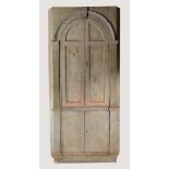 A GEORGE III BLUE PAINTED PINE CORNER CUPBOARD, the arched panel doors enclosing shelves within