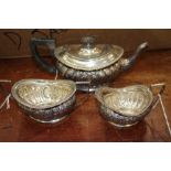 A THREE-PIECE SILVER BACHELORS TEA SET, the teapot with ovoid form and gadrooned decoration, squared