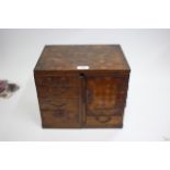 A 19TH CENTURY JAPANESE PARQUETRY ADJUSTABLE TABLE CABINET with stained brass mounts and lacquered