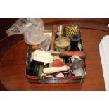 A SMALL COLLECTION OF MISCELLANEOUS ITEMS in an old biscuit tin to include an ebony hair tidy,