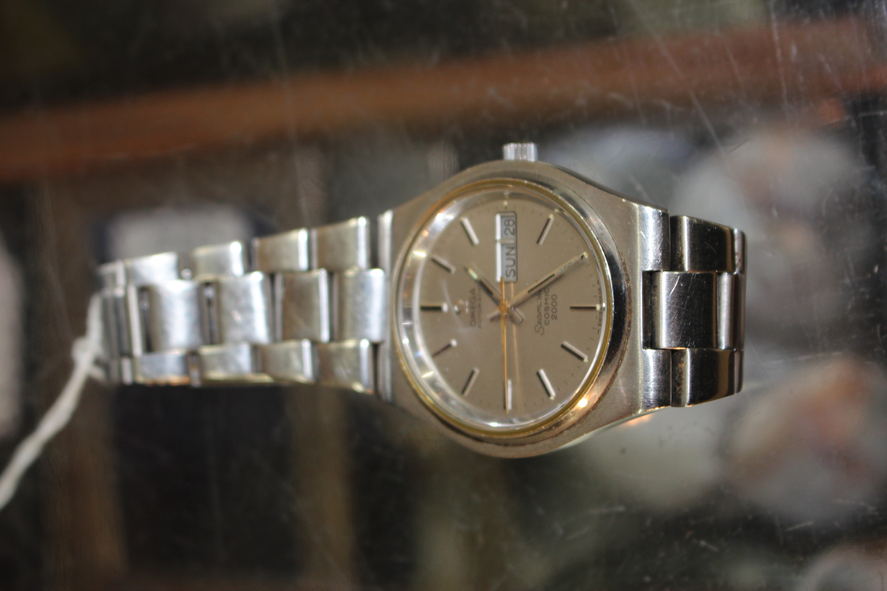 A GENTS OMEGA SEAMASTER COSMIC 2000 AUTOMATIC WRISTWATCH with brushed steel dial and case with a