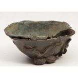 AN OLD ORIENTAL CARVED ROSEWOOD LIBATION CUP decorated with peach branches and with a brass liner,