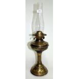 AN OLD BRASS OIL LAMP with reeded column support on circular spreading base, 58cm high overall