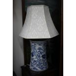 A LARGE BLUE AND WHITE TABLE LAMP of cylindrical waisted form decorated all over with trailing