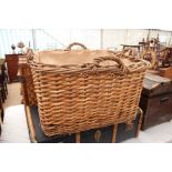 A RECTANGULAR WICKER BASKET with four handles and hessian lined interior 49cm wide x 52.5cm high