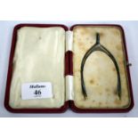 A PAIR OF NOVELTY SILVER SUGAR NIPS in the form of a wishbone in a fitted case together with a