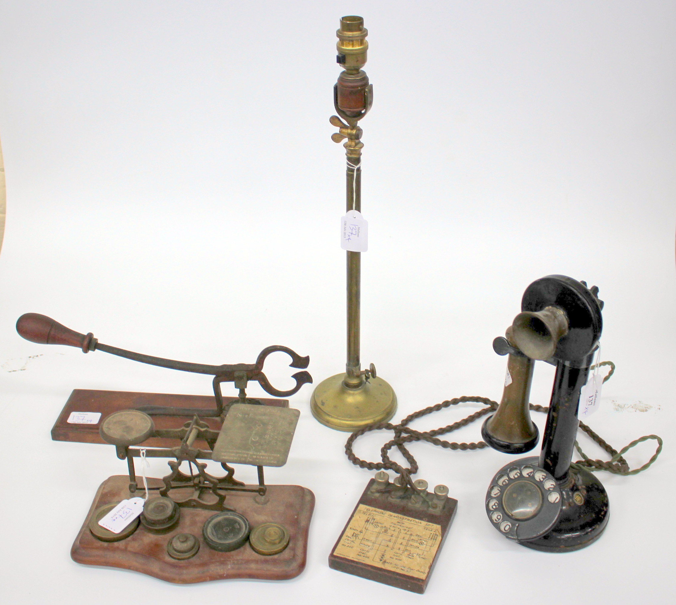 AN OLD BLACK LACQUERED CANDLESTICK TYPE TELEPHONE set up as a telephone demonstration set together