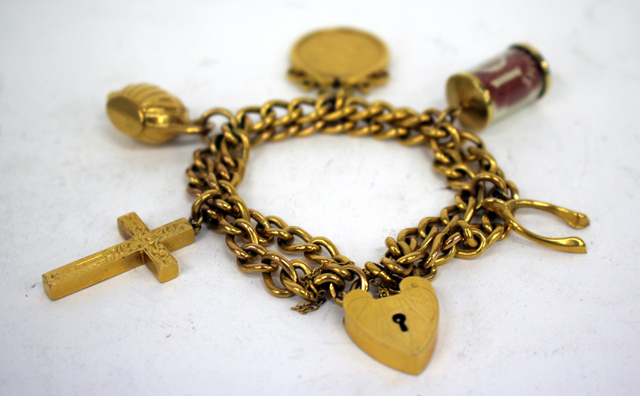 A 9-CARAT GOLD CHARM BRACELET together with a number of yellow metal charms and a 1903 sovereign