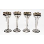 A SET OF FOUR SILVER VASES with tulip shaped top, weighted cylindrical stems and circular