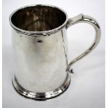 A SILVER TANKARD of inverse tapering form with beaded rim and scrolling handle engraved armorial