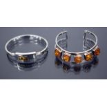 A SILVER BRACELET set with five pieces of amber together with a further amber set silver bracelet (