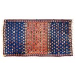 A MIDDLE EASTERN KELIM with a repeating geometric pattern on brick red and mid blue grounds, 150cm x