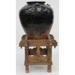 A LARGE BLACK GLAZED MARTABAN OVOID TERRACOTTA JAR, with three looped handles and standing on Indian