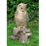 A LARGE POTTERY SCULPTURE of a long eared owl seated on a naturalistically formed base 63cm tall