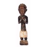 A 20TH CENTURY CONGOLESE CARVED WOODEN FIGURE of a woman in a white skirt, 74cm tall