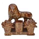 A 19TH CENTURY SALT GLAZED STONEWARE SPILL VASE, modelled as a lion above two baskets of fruit and