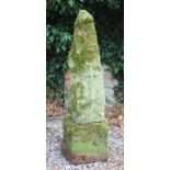 AN ANTIQUE CARVED STONE GOTHIC STYLE FINIAL on a rough cut stone base, 116cm high overall