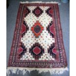 AN ORIENTIAL CREAM GROUND RUG DECORATED WITH ANIMALS and within a banded border, 186cm x 113cm