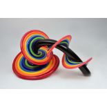 A CONTEMPORARY GLASS SCULPTURE of spiralling multi coloured tubes, twisting around a central black