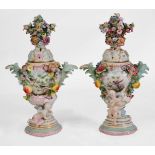 A PAIR OF CONTINENTAL PORCELAIN FLOWER DECORATED VASES and covers, pierced lids and foliate