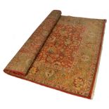 A LARGE RUST GROUND ZIEGLER RUG with dense foliate field within a multiple banded foliate border,