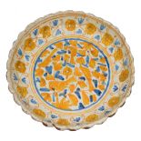 A CONTINENTAL, PROBABLY FRENCH, FAIENCE TAZZA of circular shell form with yellow and blue glazed