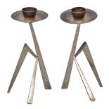 A PAIR OF SILVER MANTIS CANDLESTICKS with circular drip pan and standing on geometric tripod base,