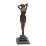 A BRONZE SCULPTURE OF A GIRL standing with her arms held behind her head and on a square stepped