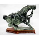 A LARGE CARVED JADEITE OR HARDSTONE SCULPTURE OF A HORSE rearing up and wearing a bridle and saddle,
