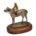 A SILVER PLATED BRONZE AND COLD PAINTED CAR MASCOT in the form of a jockey seated on the back of a
