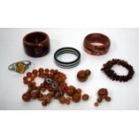 A POSSIBLY AMBER BEADED NECKLACE (restringing required) together with two faux amber bangles, a