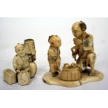 A 19TH CENTURY JAPANESE CARVED IVORY OKIMONO in the form of a peach seller and his son, 7.5cm long