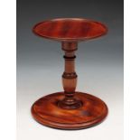 A MAHOGANY CANDLE STAND with dish top and turned stem, 19.5cm high