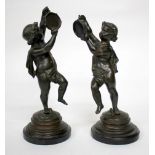 A PAIR OF GRANDE TOUR TYPE BRONZE CHERUBS with tambourines on cylindrical hardstone bases, each 23cm