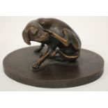 A SMALL BRONZE SCULPTURE OF A DOG enjoying a scratch, the oval base with inscription dated 1961,