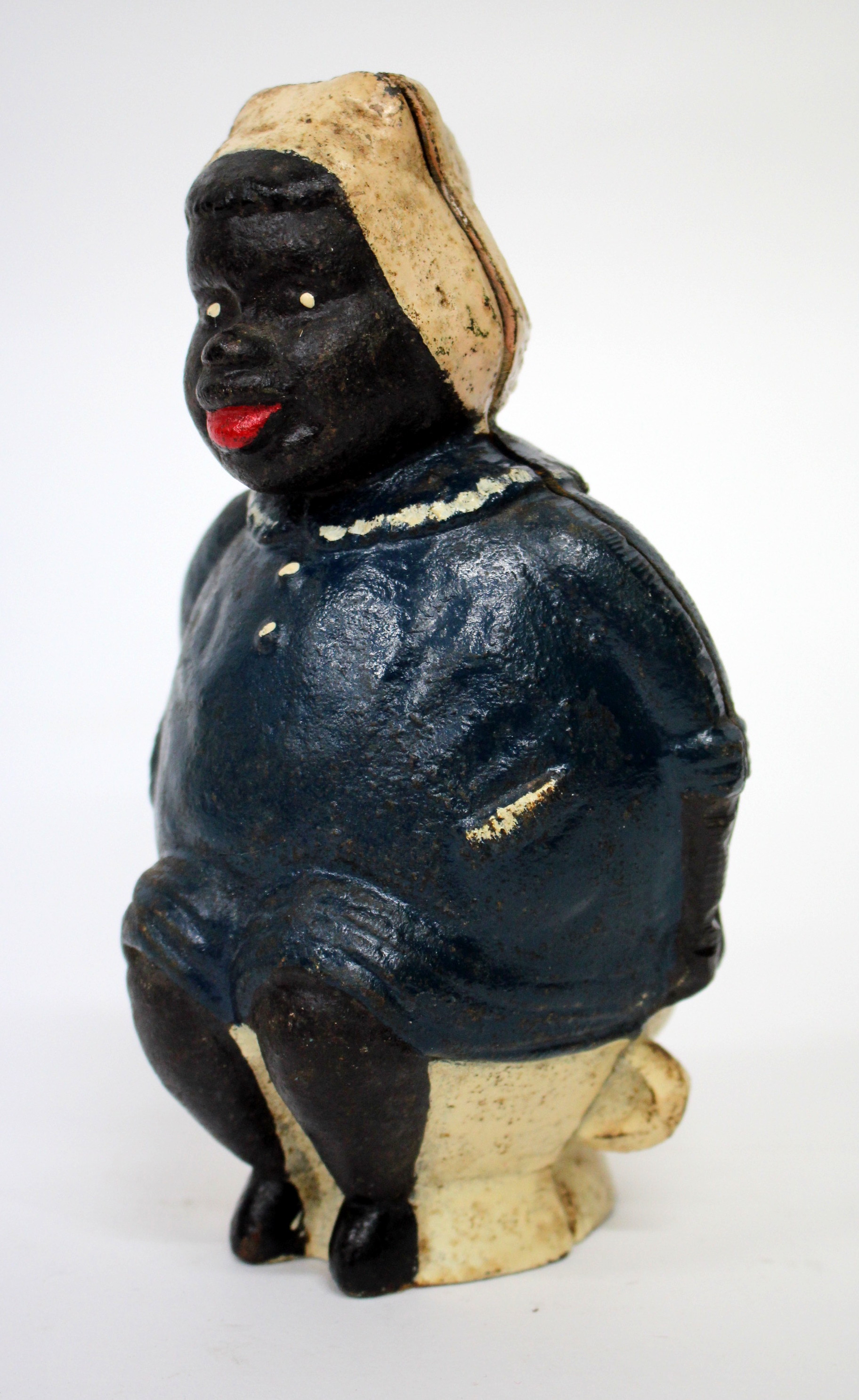 A CAST IRON NOVELTY MONEY BOX in the form of a large woman seated upon the toilet, 20cm tall