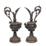 A PAIR OF GRAND TOUR STYLE BRONZE EWERS with open work handles and figure mounts, 29cm high