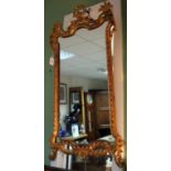 A CARVED GILT WOOD HANGING WALL MIRROR with shaped mirror plate, the frame with acanthus leaf swags,