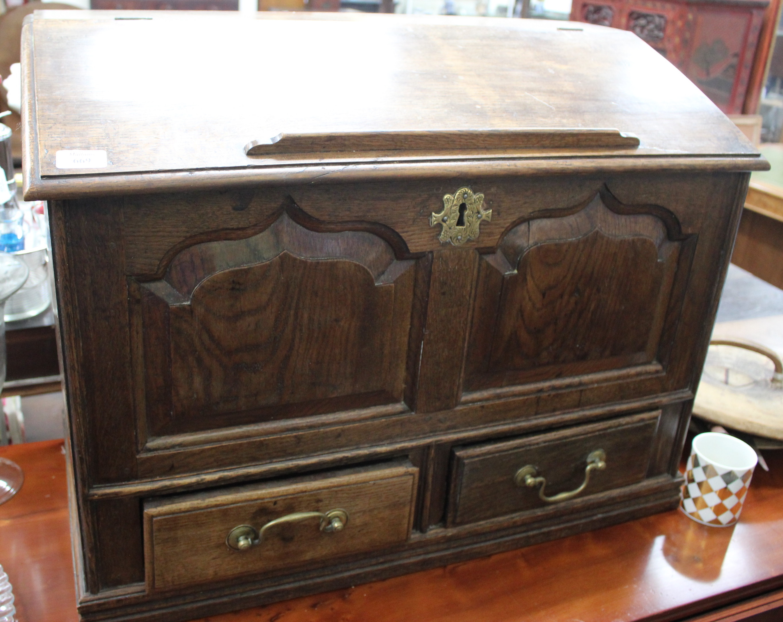 AN OLD OAK TABLE TOP DESK the fall front enclosing a well within and three small drawers and with