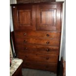 A 19TH CENTURY OAK LINEN PRESS with twin panelled cupboard doors over five graduated long drawers