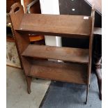 AN OLD OAK BOOKSHELF with angled book stands and pierced carrying handles to the sides, 68cm wide