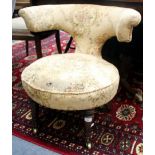 A LATE VICTORIAN UPHOLSTERED LOW CHAIR with a horseshoe back, turned front legs and Copes casters,