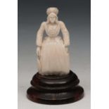 A CONTINENTAL IVORY MINIATURE FIGURE OF A FLEMISH WOMAN in flowing robes on a wooden socle, 5cm