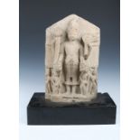 AN INDIAN HEAVY SANDSTONE STELE representing the standing Vishnu, 45cm high on a black painted