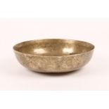 AN ANTIQUE PERSIAN BRASS 'MAGIC' BOWL with engraved decoration and star base, 20cm diameter