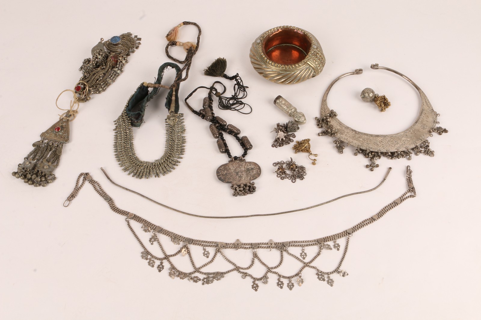 A COLLECTION OF INDIAN SILVER COLOURED METAL JEWELLERY TO INCLUDE six pendants, a seal, a necklace