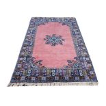 A MOROCCAN RABAT PINK GROUND CARPET with blue central foliate medallion and wide border, 315 x