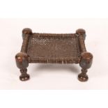 A MIDDLE EASTERN CARVED WOODEN STOOL OR TABLE with woven rattan top on ring turned legs, 50 x 40cm