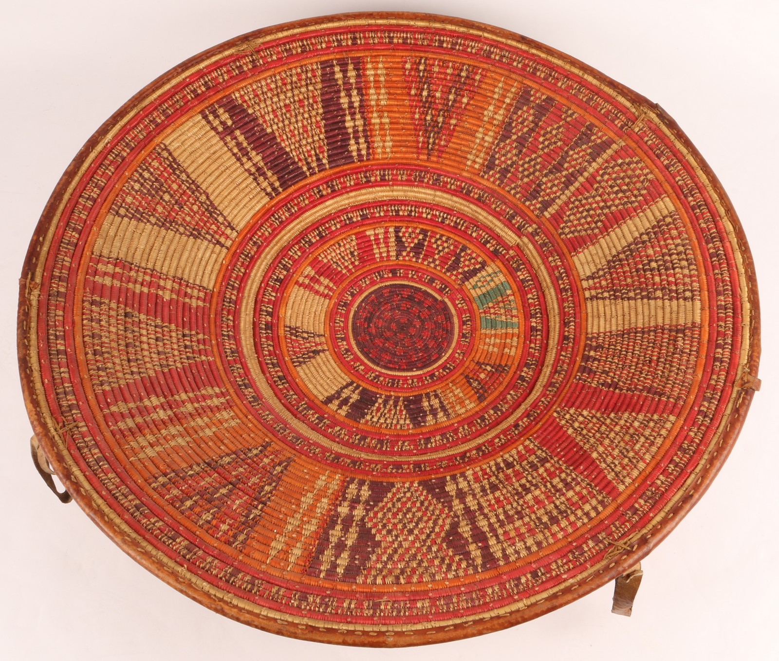 A FINE HARAR ETHIOPIAN CIRCA 1950 BASKET with radiating polychrome decoration, leather edge and
